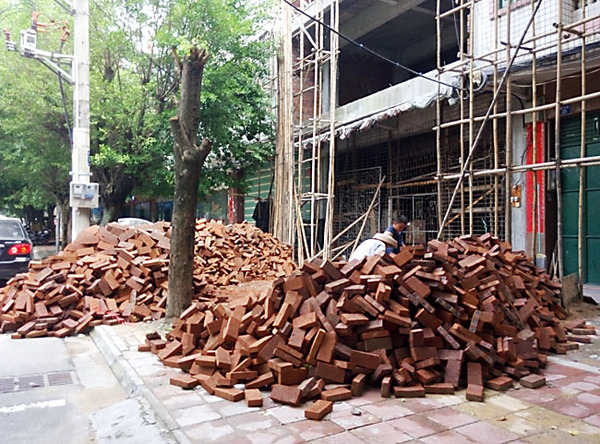 建設(shè)路建筑材料亂堆放，人行道變“攔路虎”
